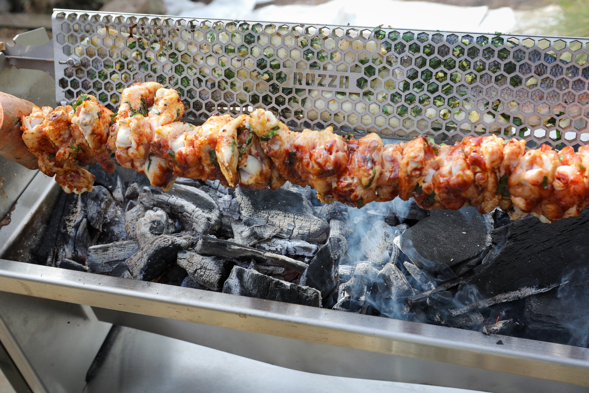 skewered meat alongsize fresh fish being cooked on the Rozza BBQ rotisserie
