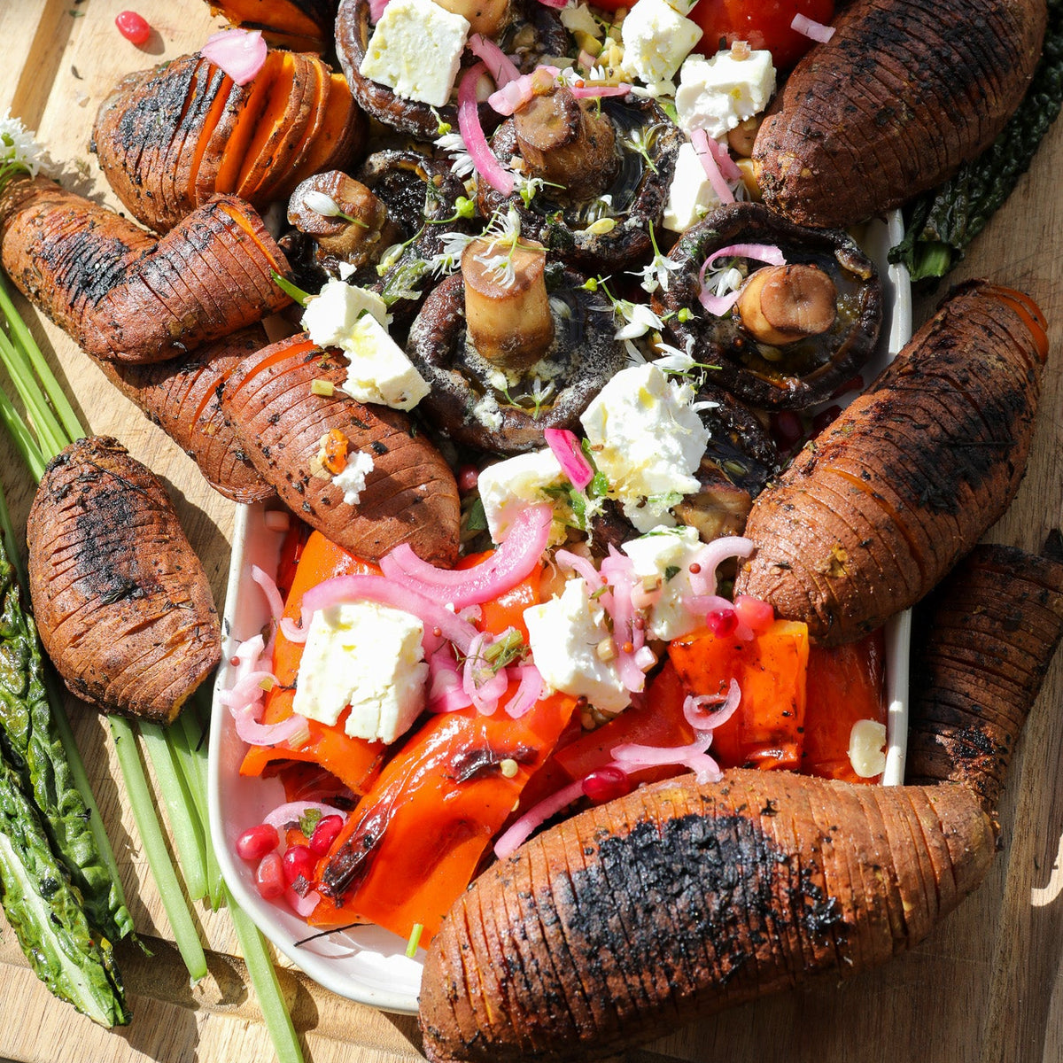 Grilled vegetables with feta cheese and tomatoes on a wooden board