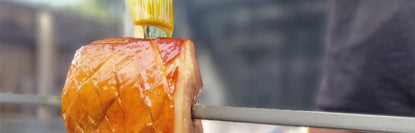 Close-up of a piece of smoked meat on a skewer with a blurred background