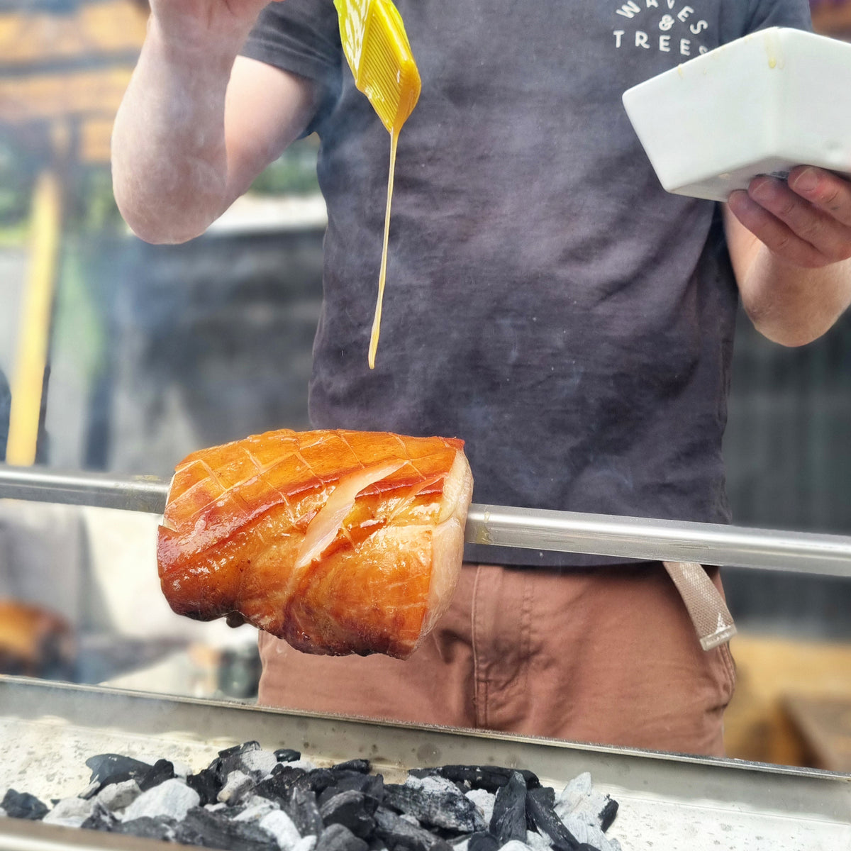 Man glazing ham roasting on the Rozza